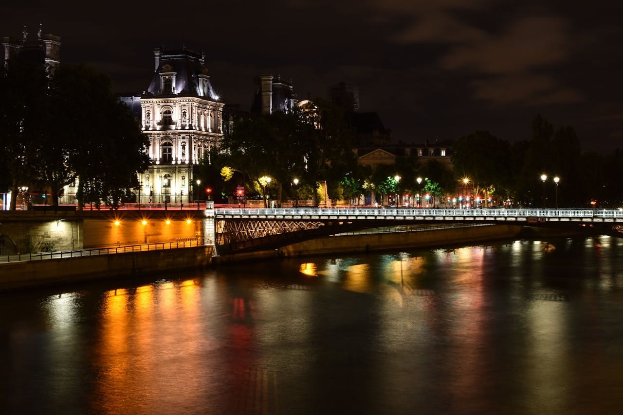 Stunning Paris night scene with Eiffel Tower and river reflections.