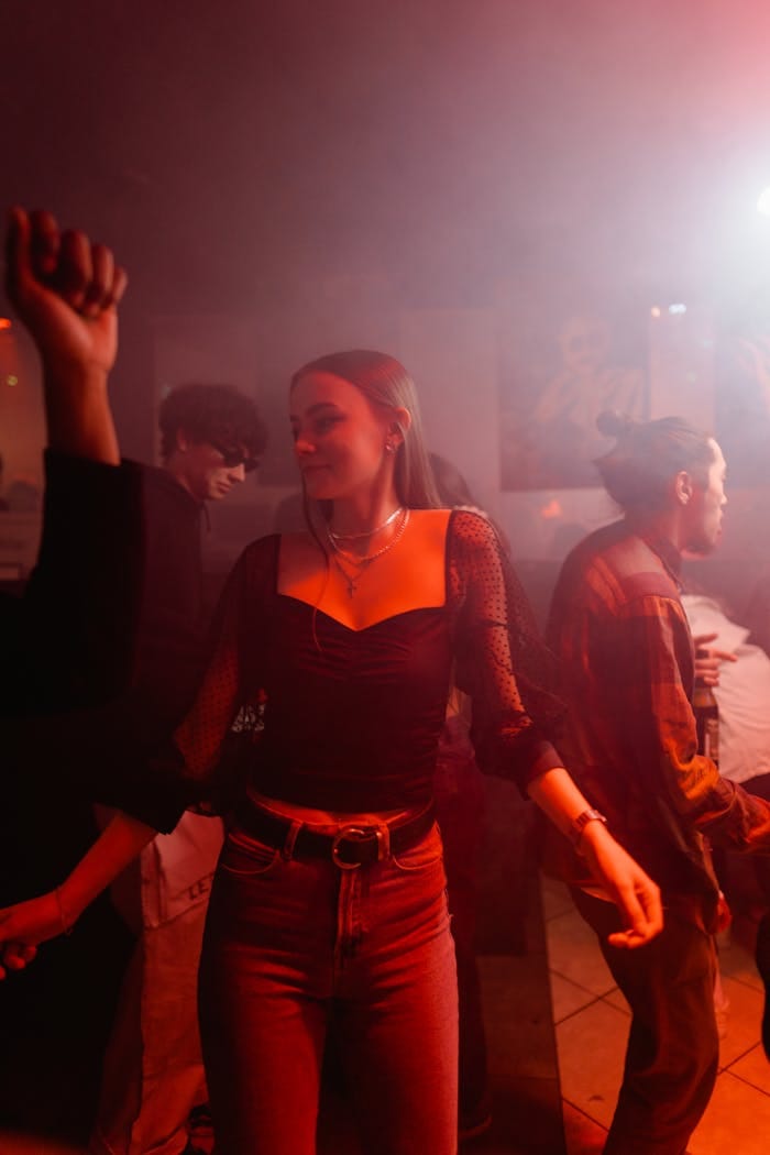 Energetic young adults dancing in a lively club with colorful lighting and dynamic atmosphere.